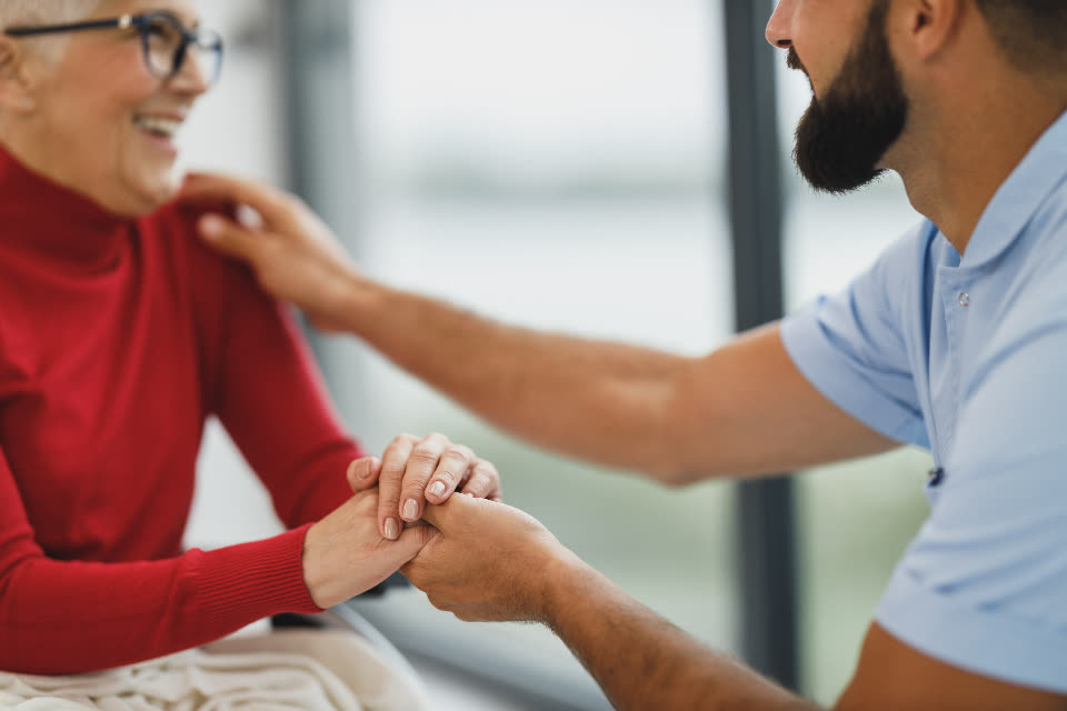 Duas pessoas de mãos dadas em uma conversa de apoio